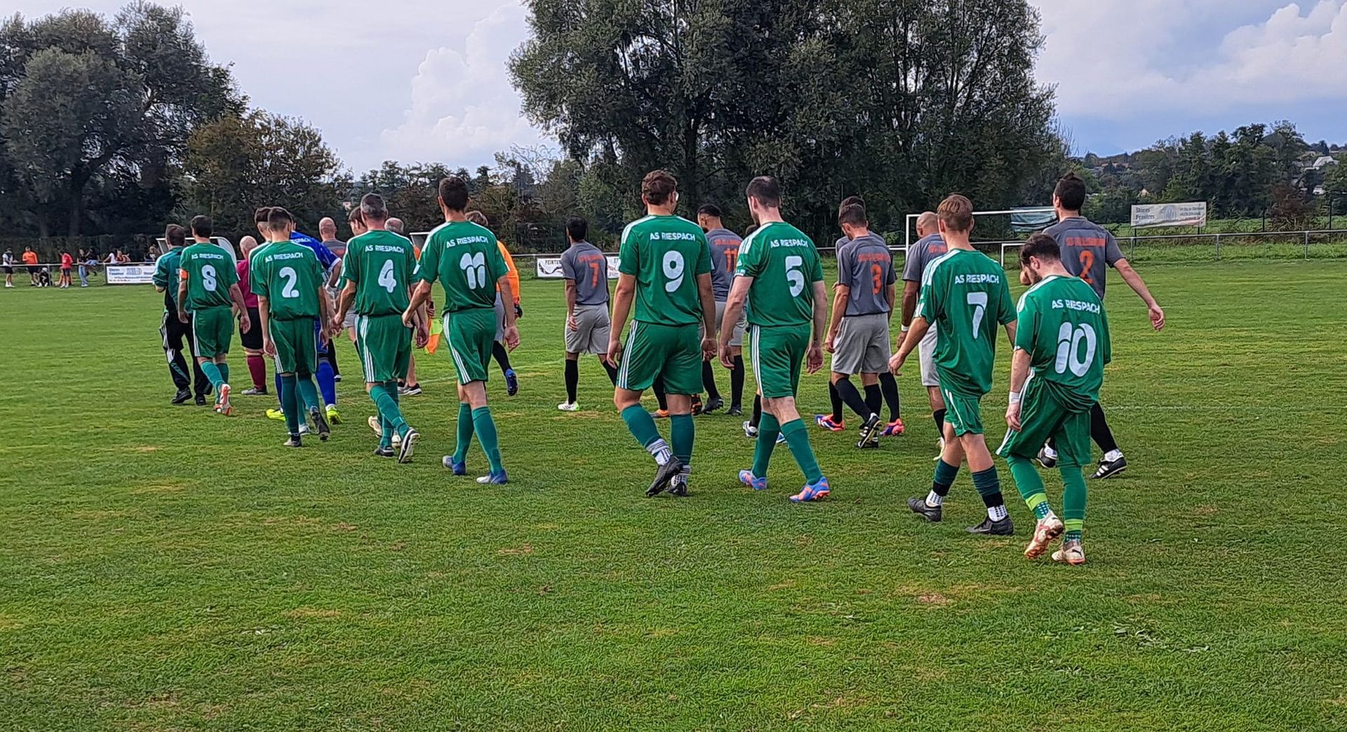 Un groupe de joueurs de football marche sur un terrain.