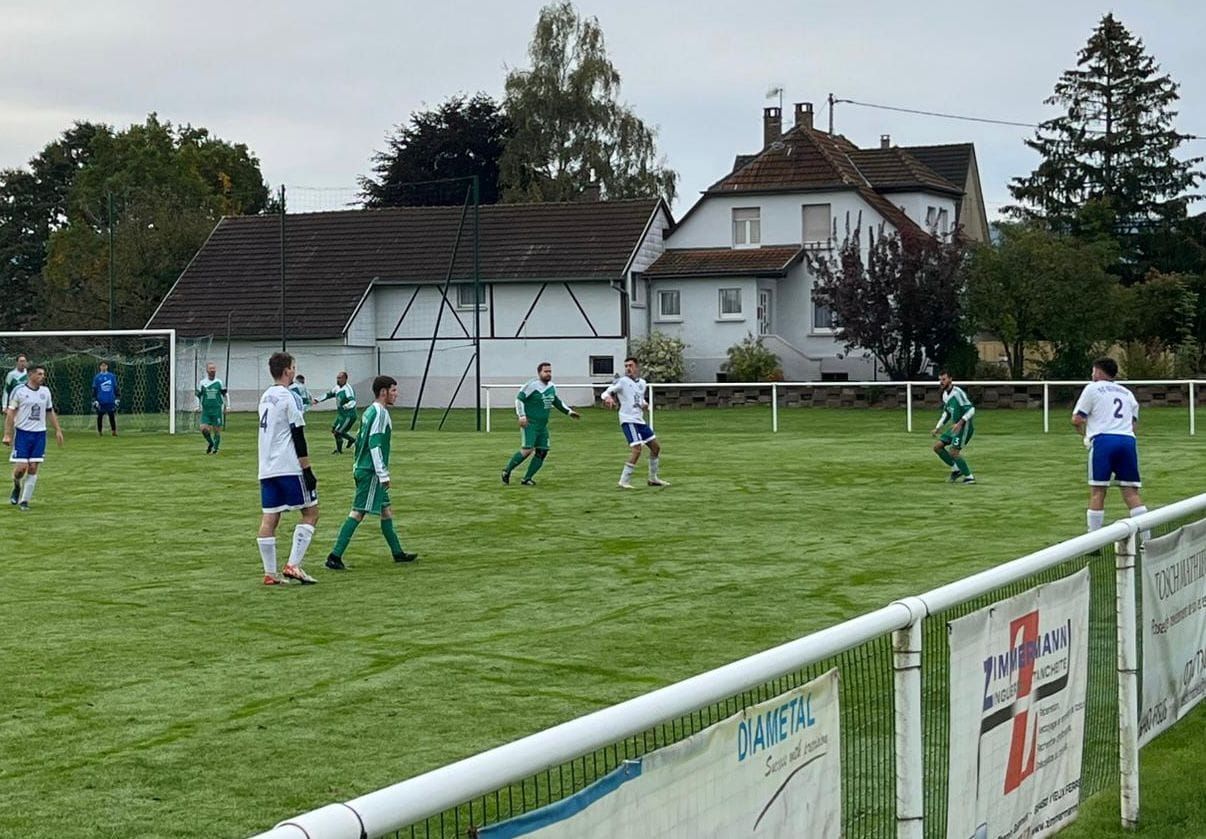 Un groupe de personnes joue au football sur un terrain