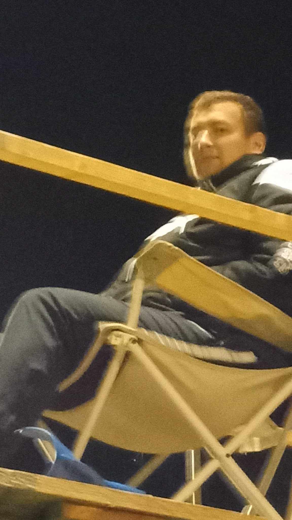 Un homme est assis sur une chaise avec les jambes croisées