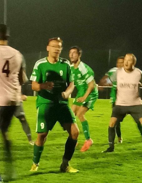 Un groupe de joueurs de football sur un terrain dont l'un porte un maillot numéro 4