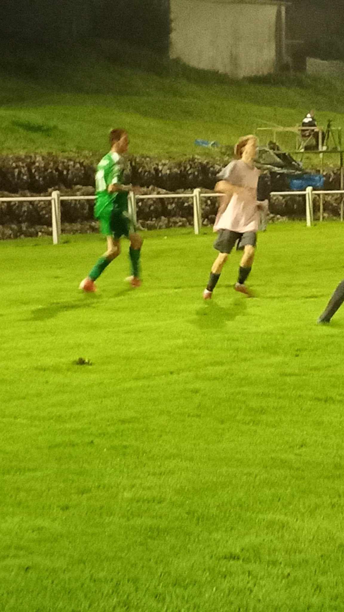 Un groupe de personnes joue au football sur un terrain.