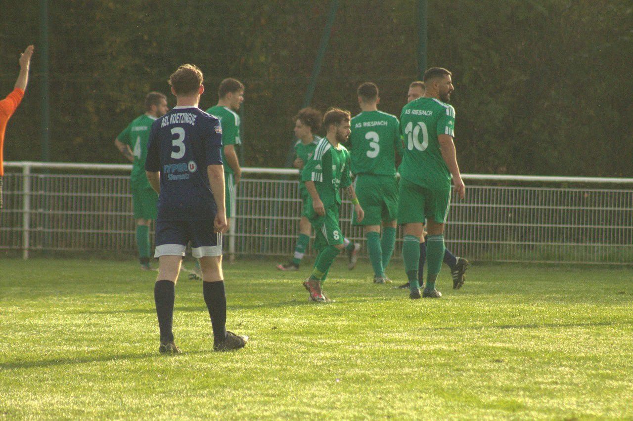 Un groupe de joueurs de football se tient sur un terrain.