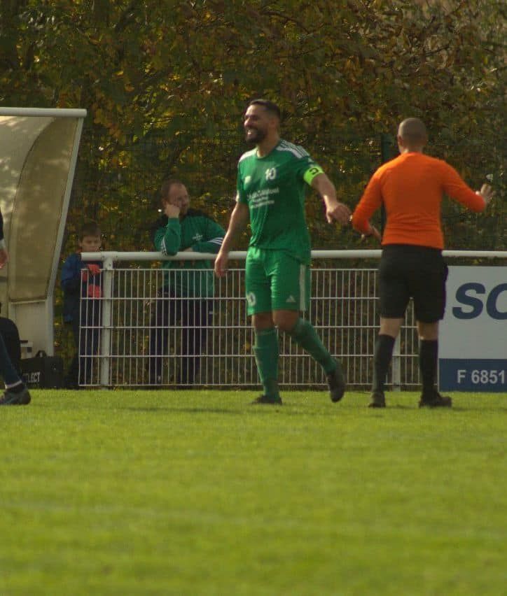 Un joueur de football portant un maillot vert avec le numéro 10 dessus