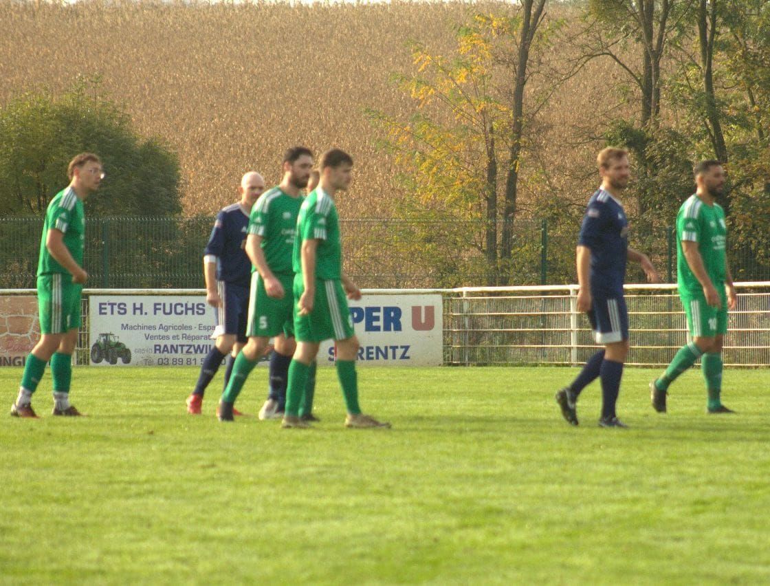 Un groupe de joueurs de football marche sur un terrain.