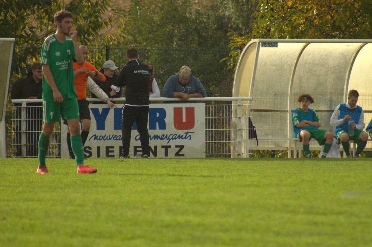 Un groupe de personnes joue au football sur un terrain.