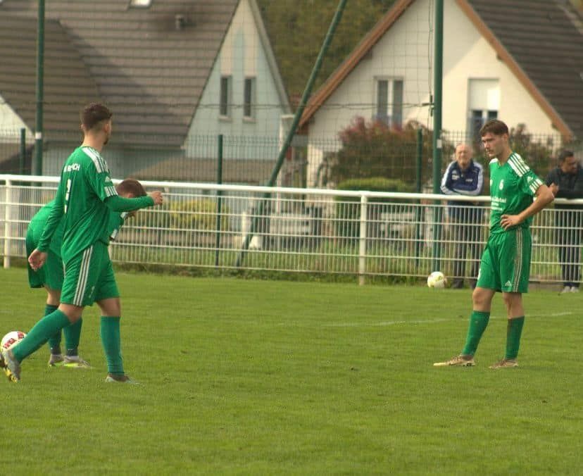 Un groupe de joueurs de football en uniformes verts sont sur un terrain