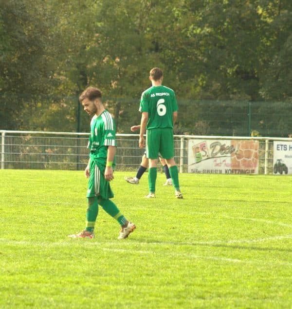 Un joueur de football avec le numéro 6 sur le dos marche sur le terrain