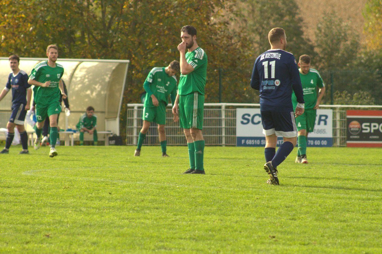 Un groupe de joueurs de football jouent à un jeu sur un terrain.