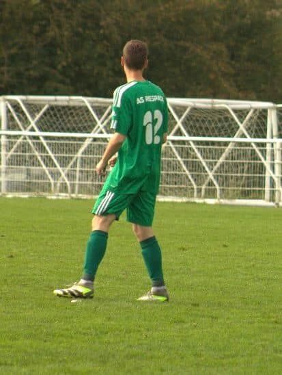 Un joueur de football portant un maillot vert avec le numéro 12 dans le dos