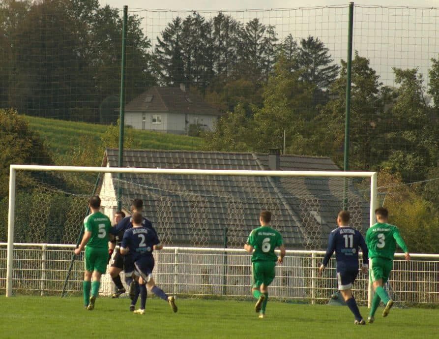 Un groupe de footballeurs court vers le but