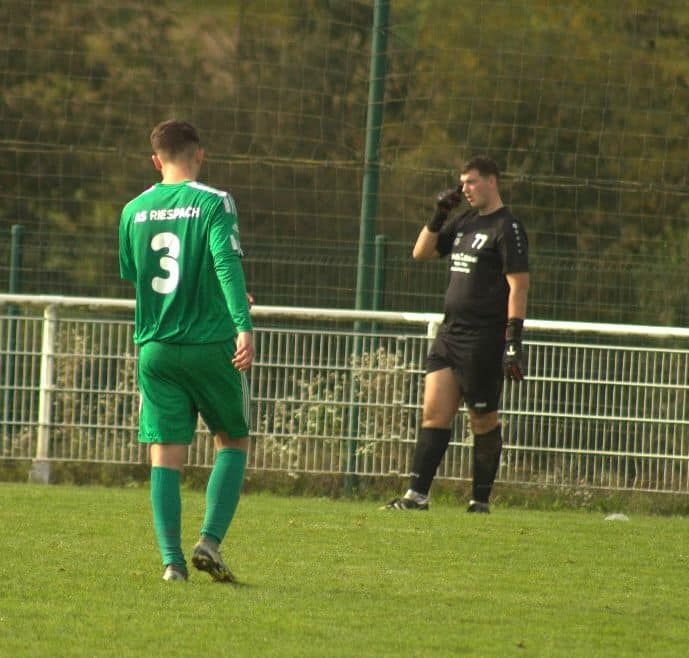 Un joueur de football portant un maillot vert avec le numéro 3 dessus