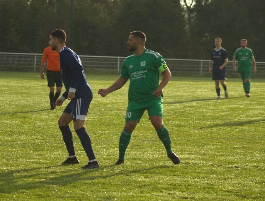 Un groupe d'hommes jouent au football sur un terrain.