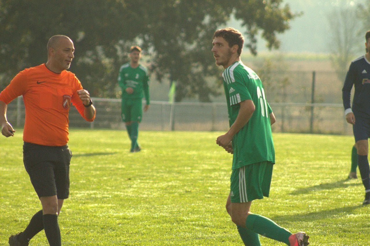 Un groupe de joueurs de football jouent à un jeu sur un terrain.