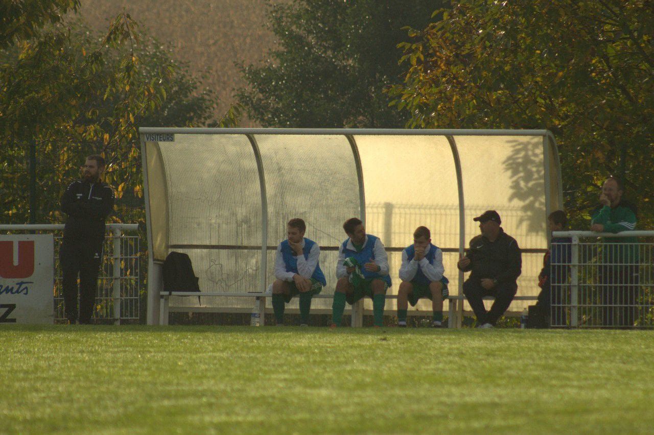 Un groupe de personnes est assis dans un abri sur un terrain de football