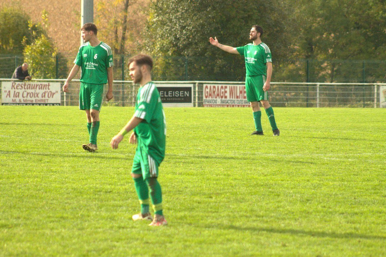 Un groupe de joueurs de football se tient sur un terrain.