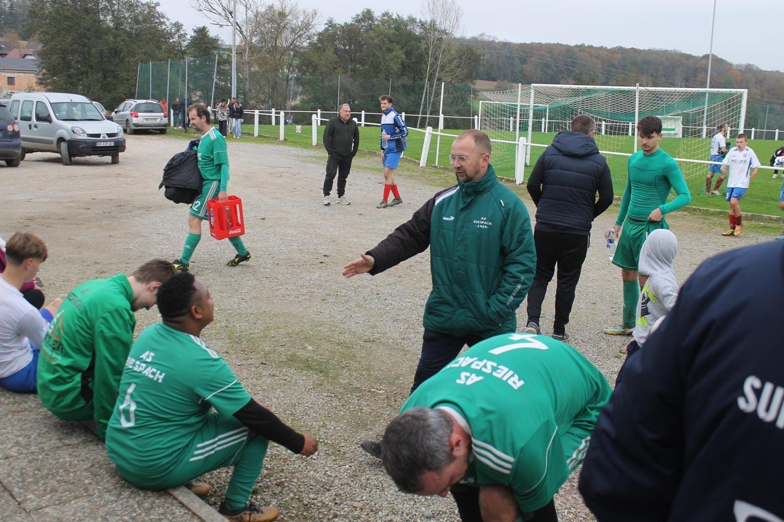 Un groupe de joueurs de football en uniformes verts sont assis par terre