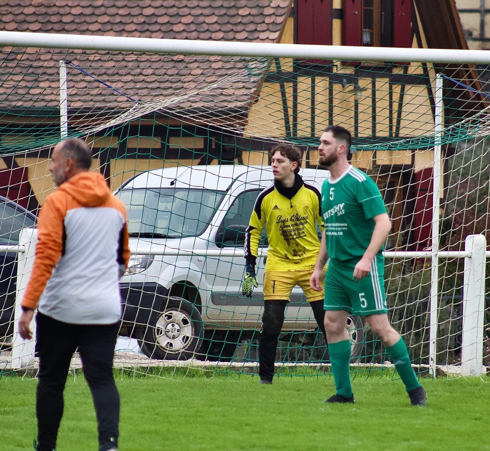 Un groupe d'hommes jouent au football sur un terrain.
