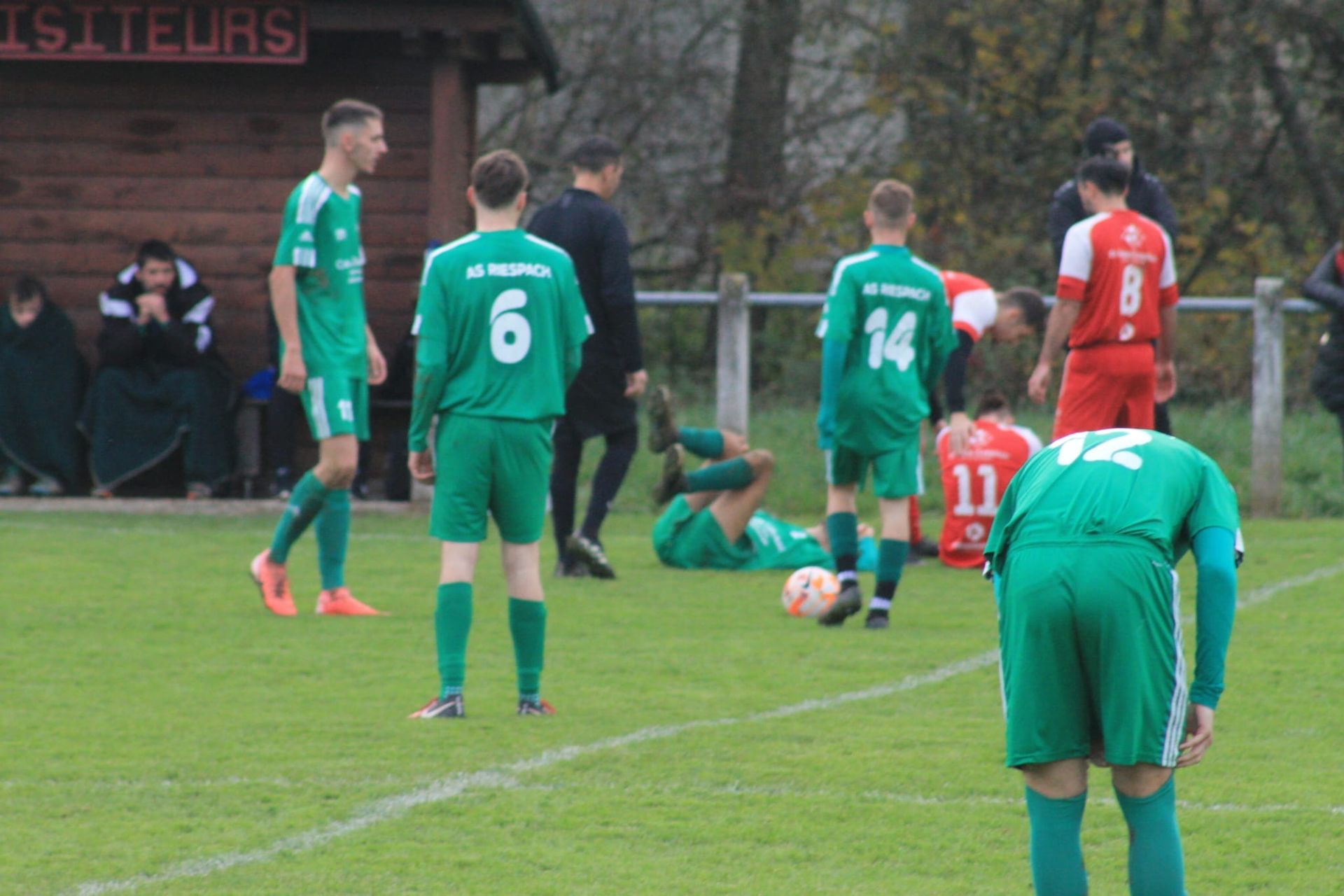 Un groupe de joueurs de football jouent à un jeu sur un terrain.