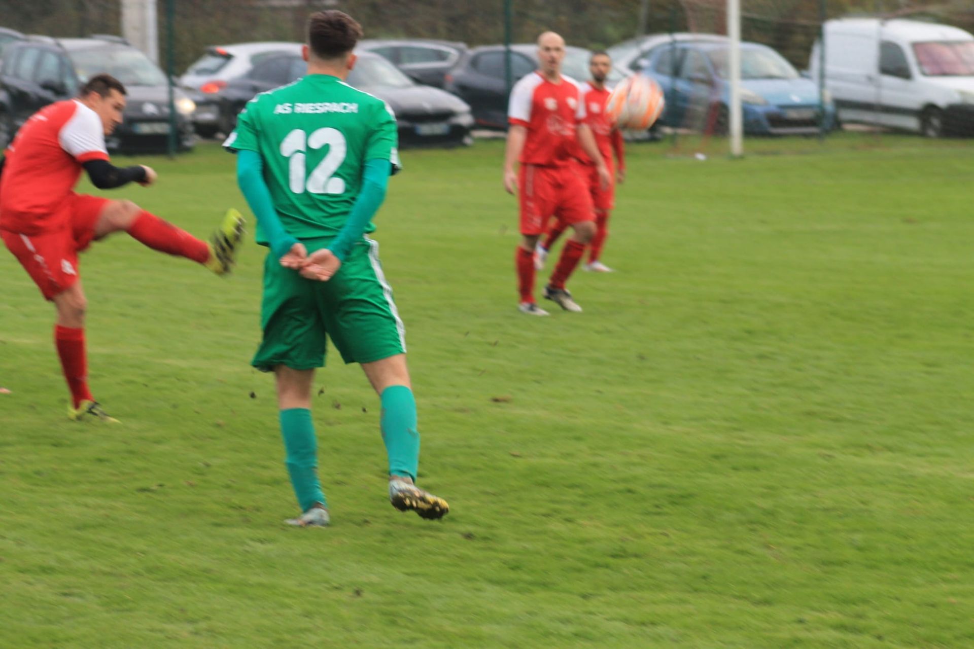Un groupe de joueurs de football jouent à un jeu sur un terrain.