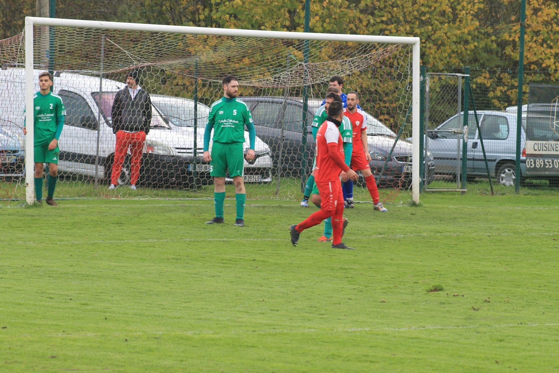 Un groupe de personnes joue au football sur un terrain.