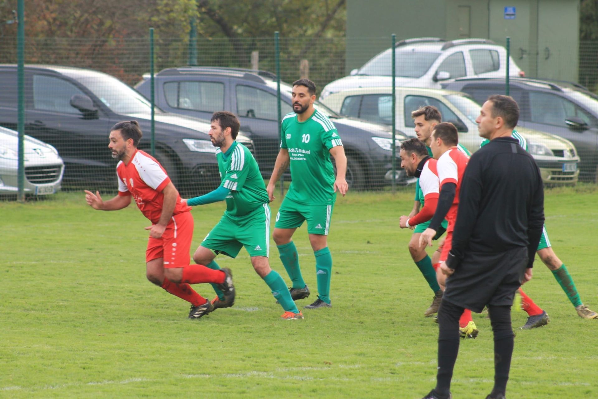 Un groupe d'hommes jouent au football sur un terrain.