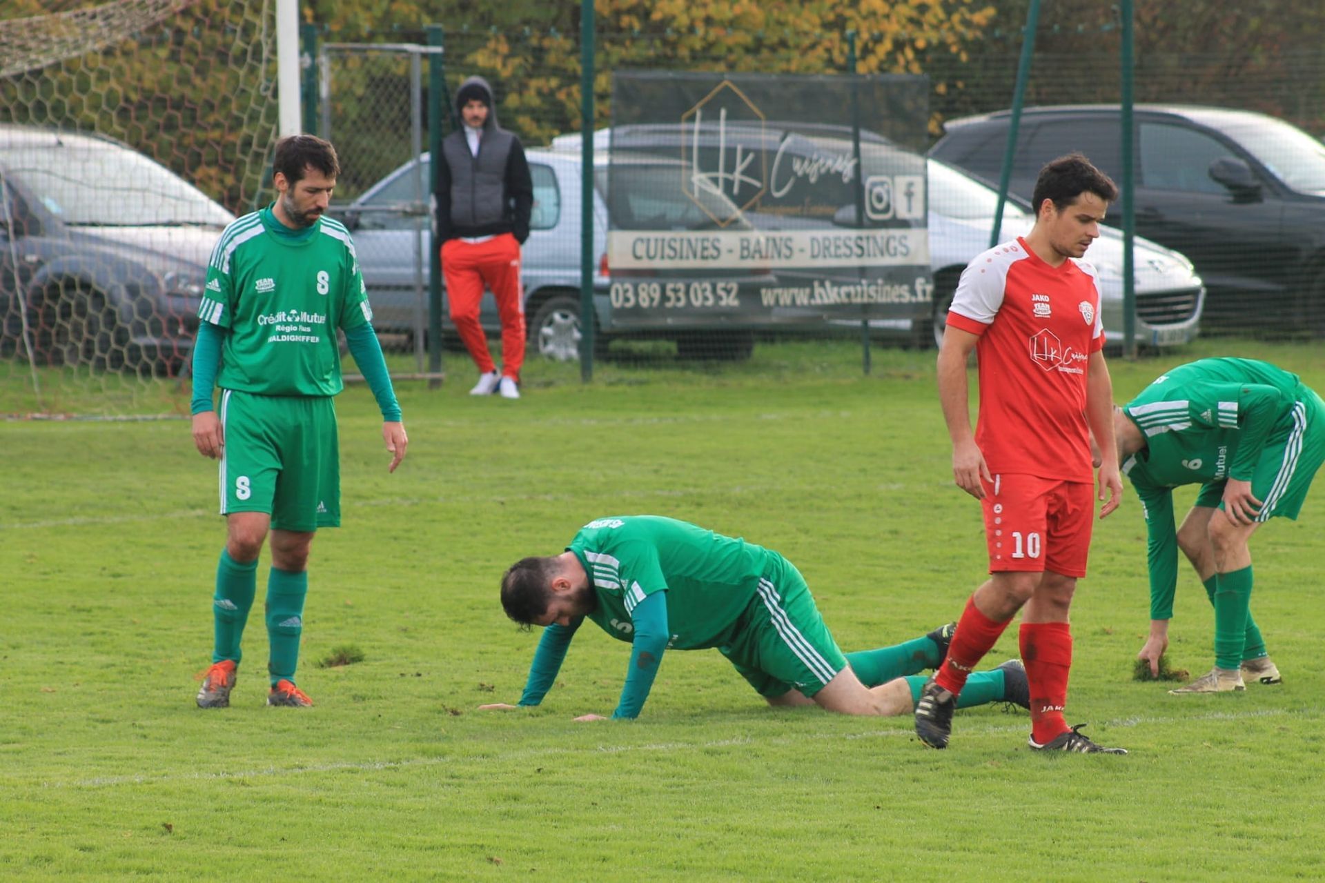 Un groupe de joueurs de football jouent à un jeu sur un terrain.