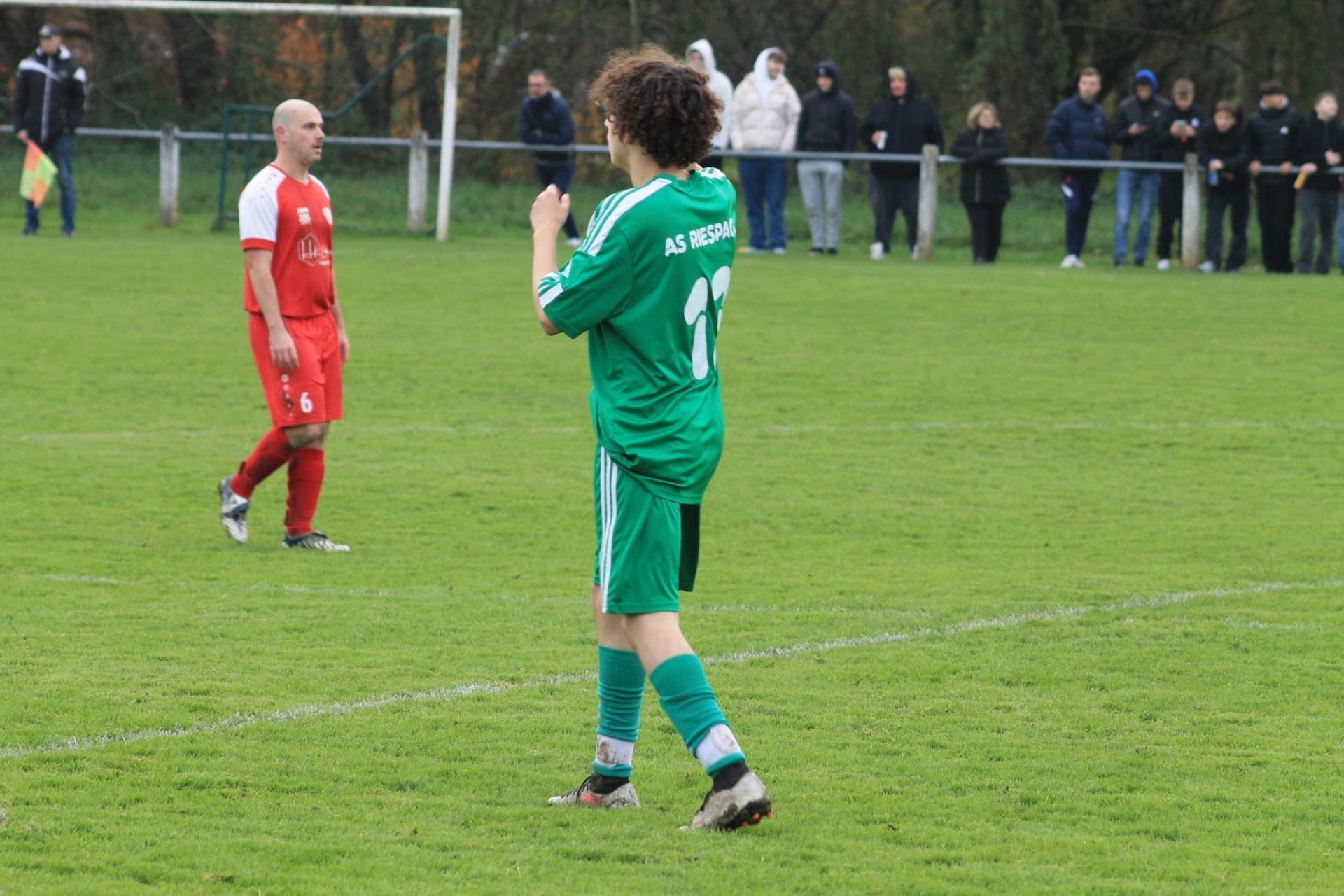 Un joueur de football portant un maillot vert avec le numéro 1 dessus