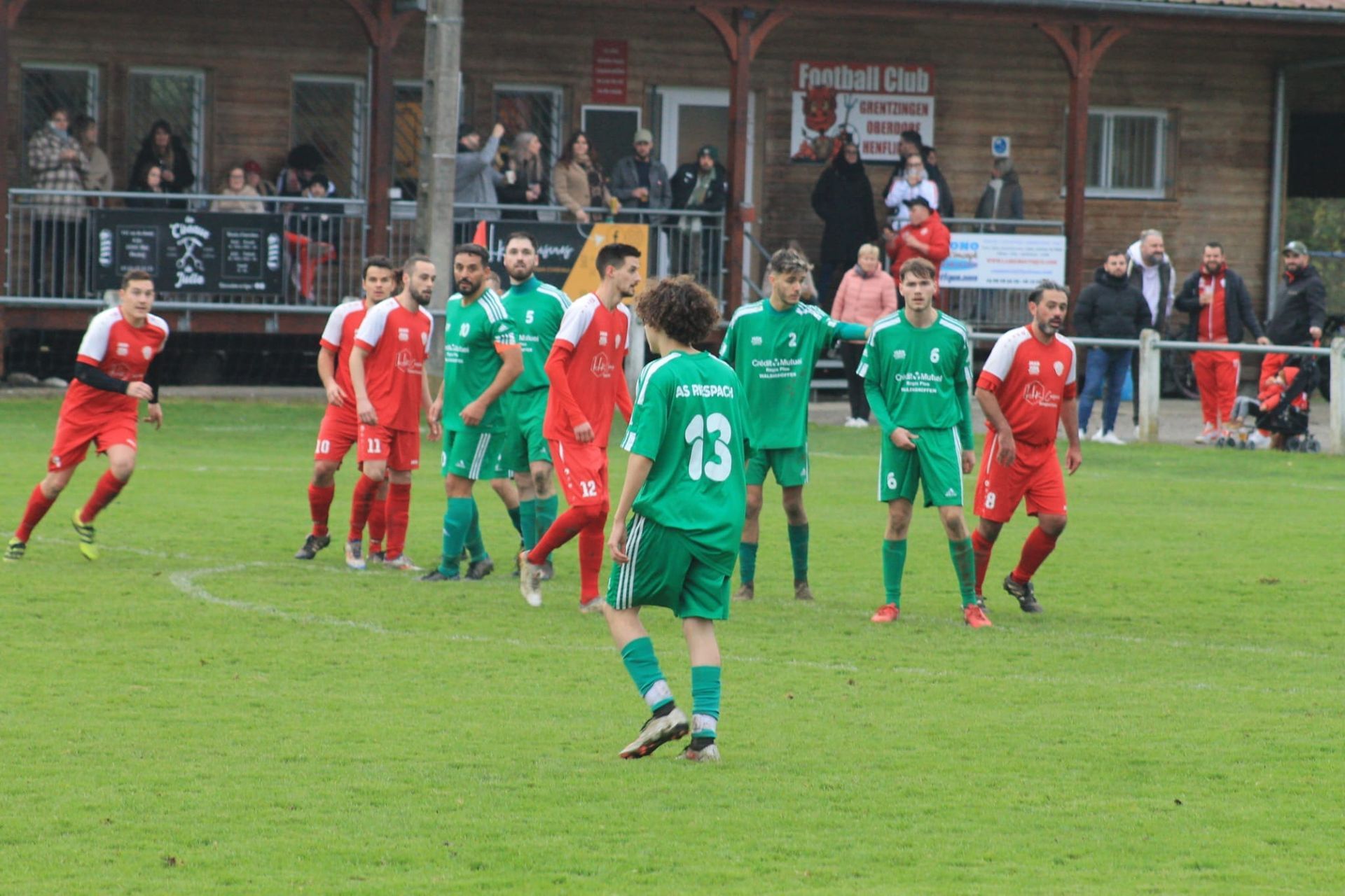 Un groupe de joueurs de football sur un terrain dont l'un porte le numéro 13