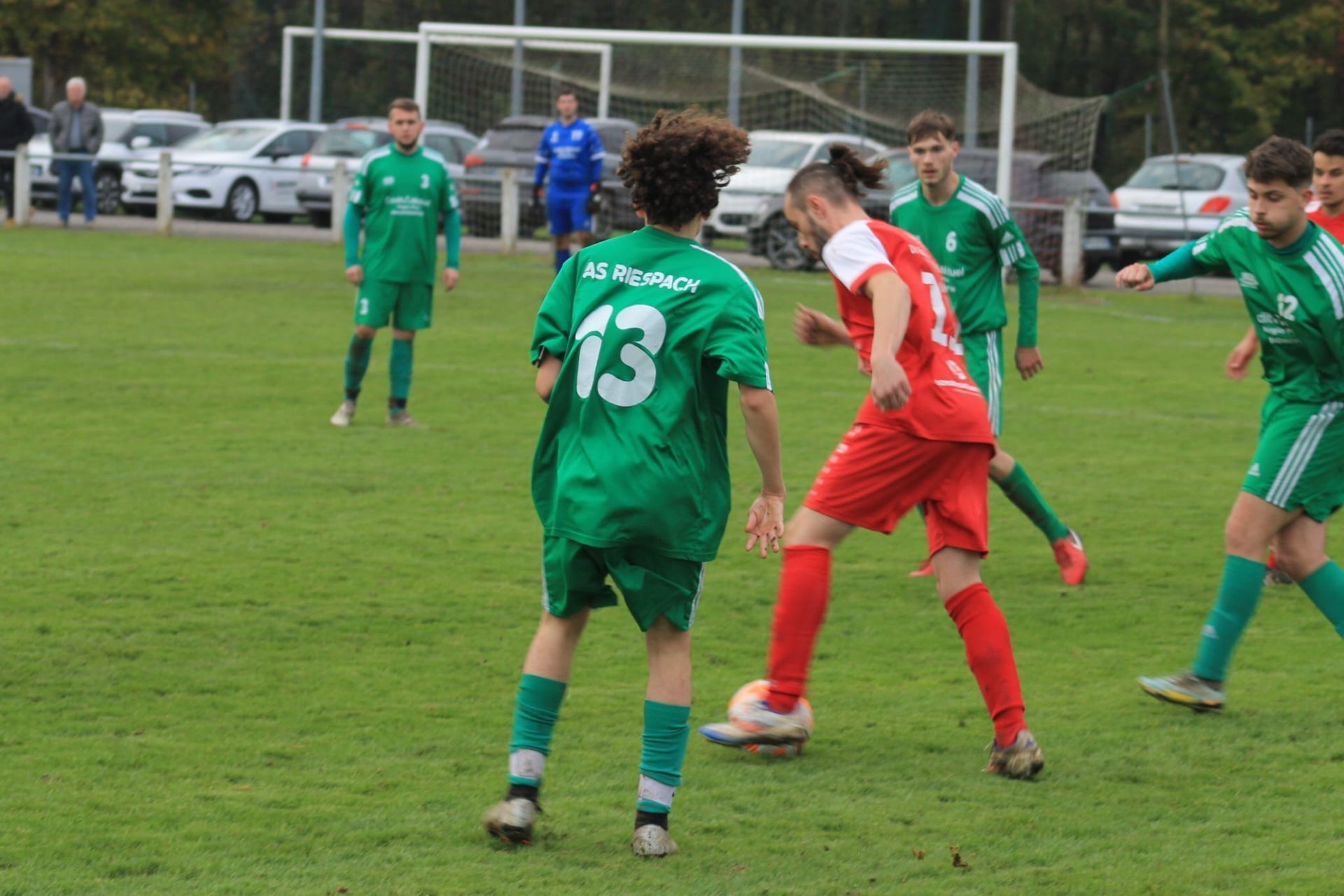 Un groupe de joueurs de football jouent à un jeu sur un terrain.