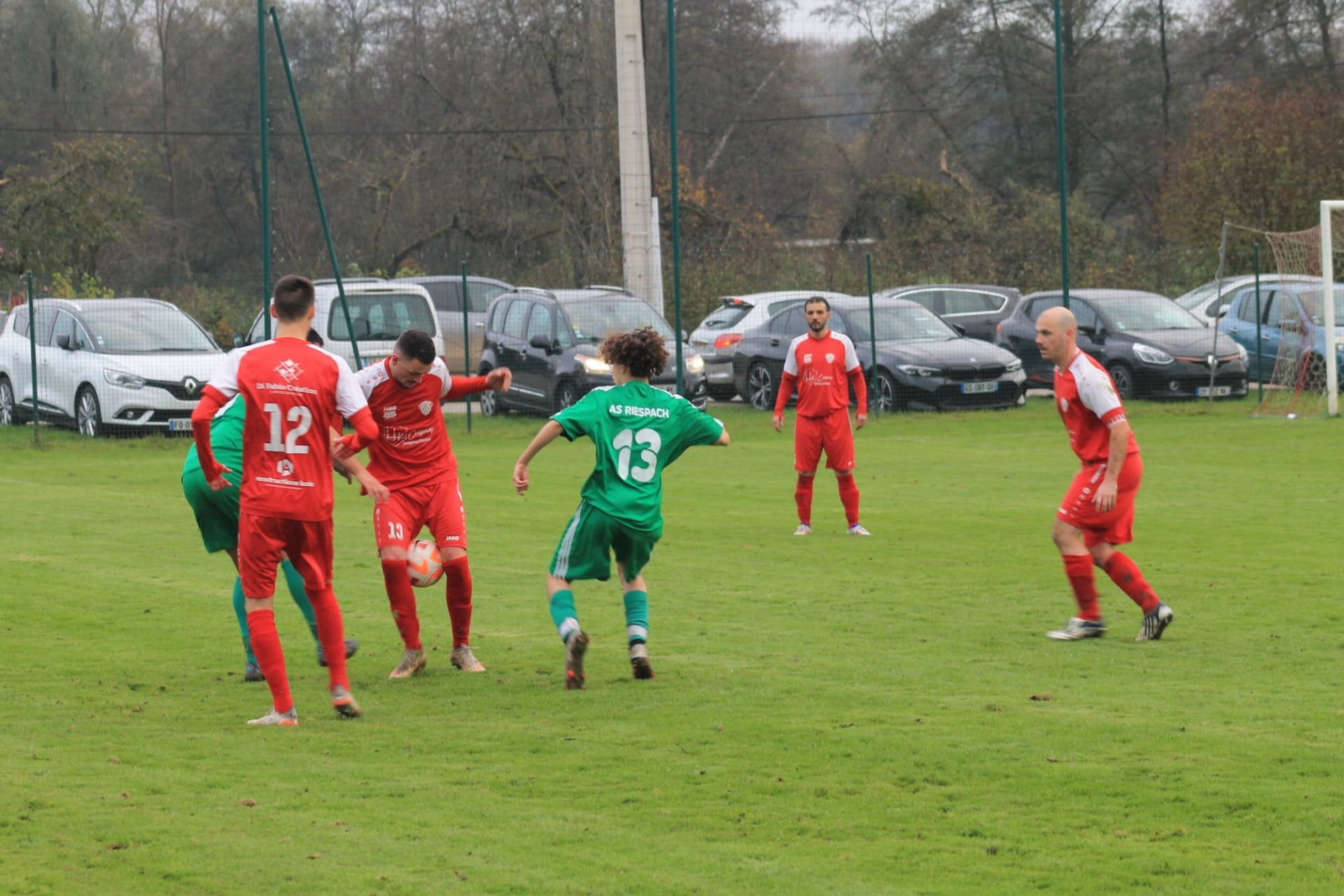 Un groupe de joueurs de football jouent à un jeu sur un terrain.
