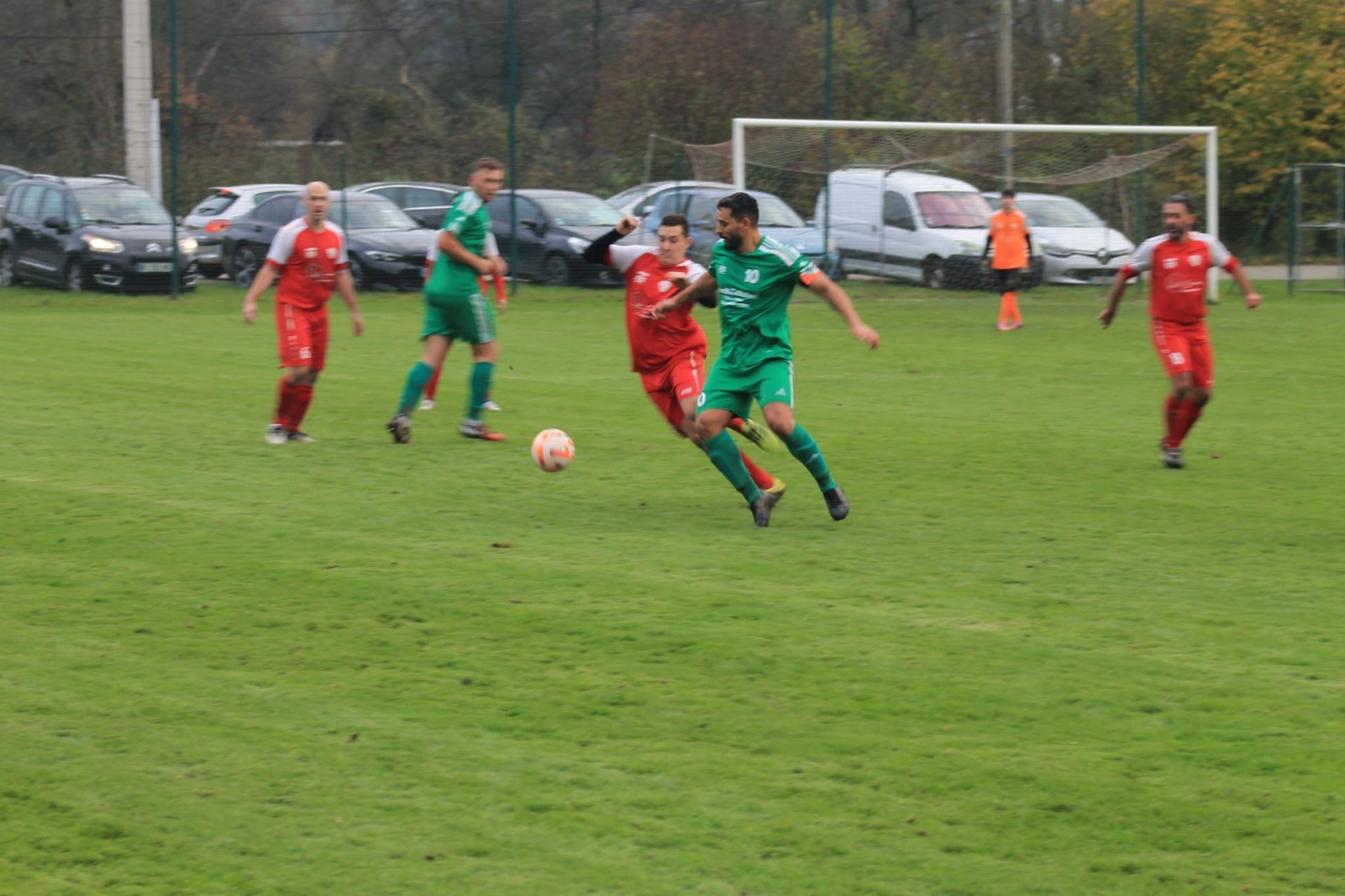 Un groupe d'hommes jouent au football sur un terrain.