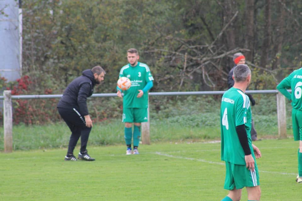 Un groupe d'hommes jouent au football sur un terrain.