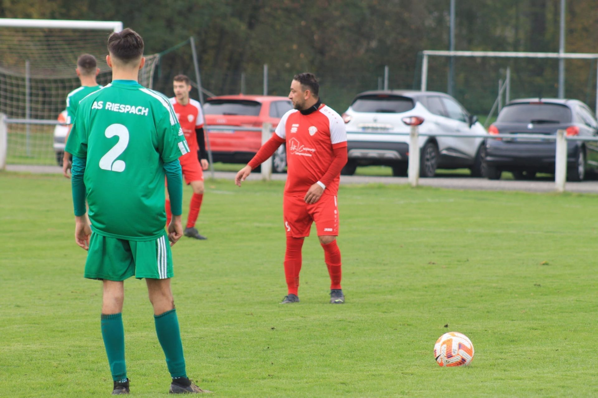 Un groupe de footballeurs jouent au football sur un terrain.