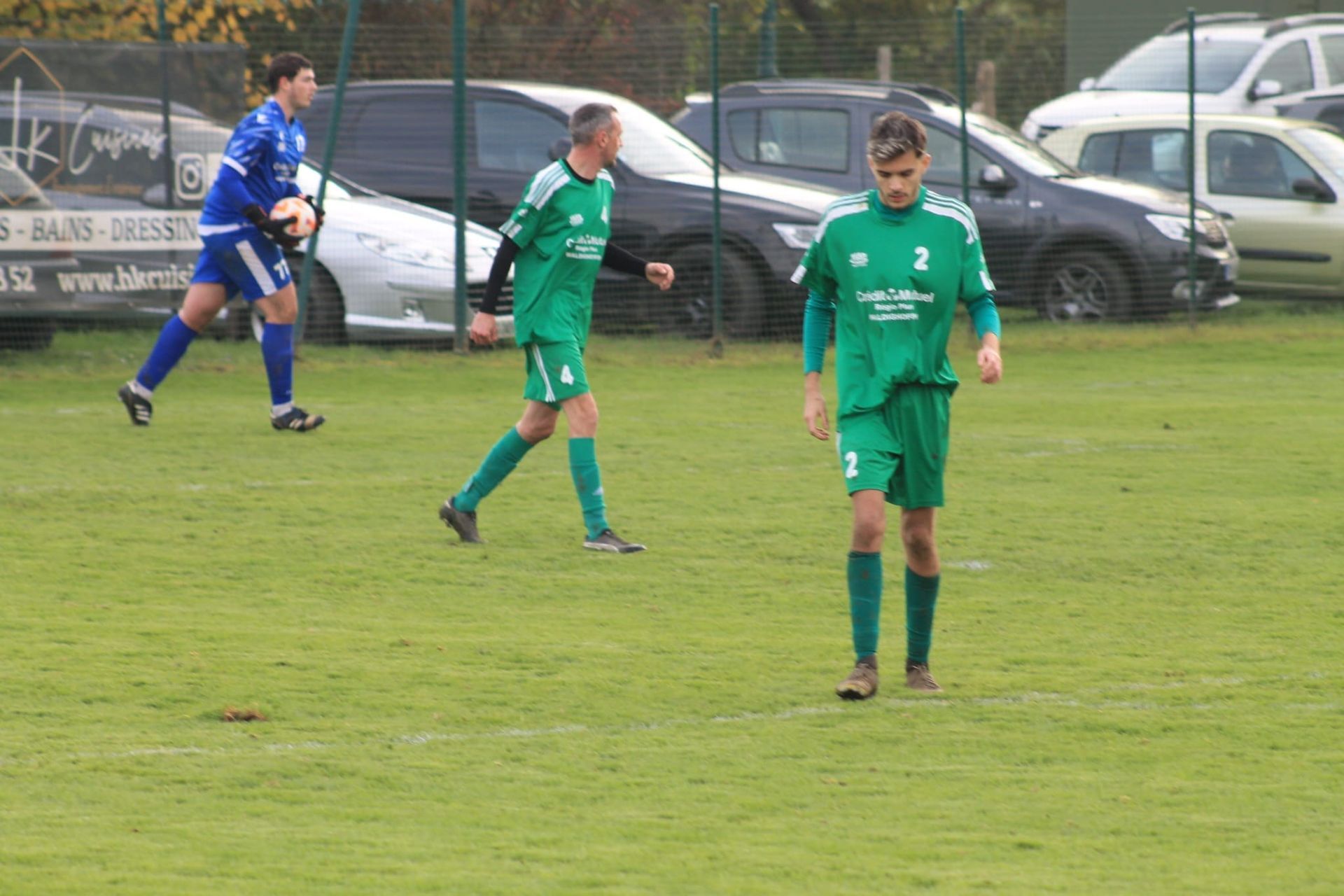 Un groupe de joueurs de football jouent à un jeu sur un terrain.