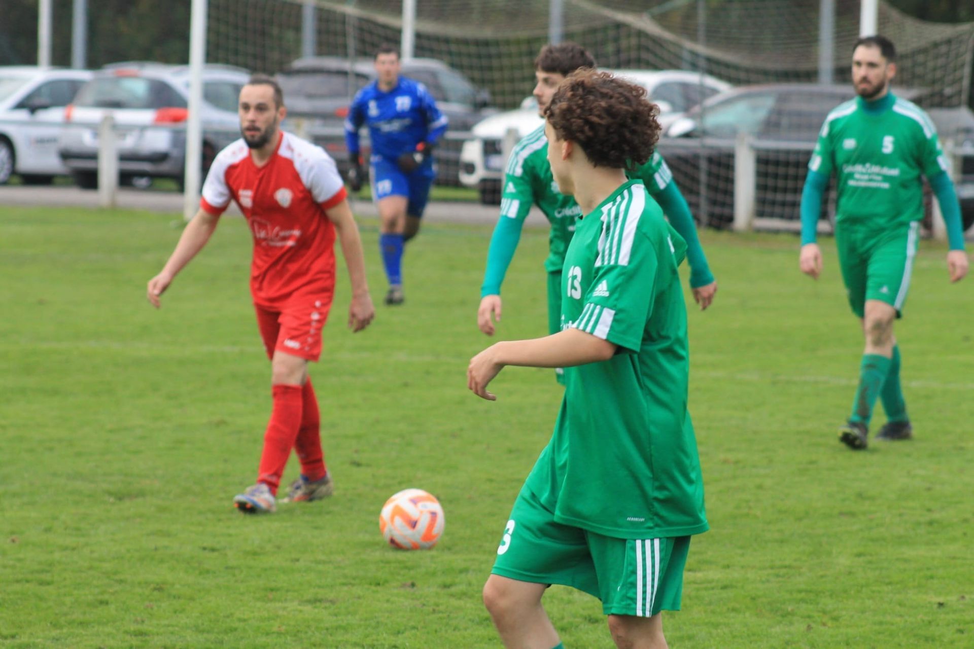 Un groupe d'hommes jouent au football sur un terrain.