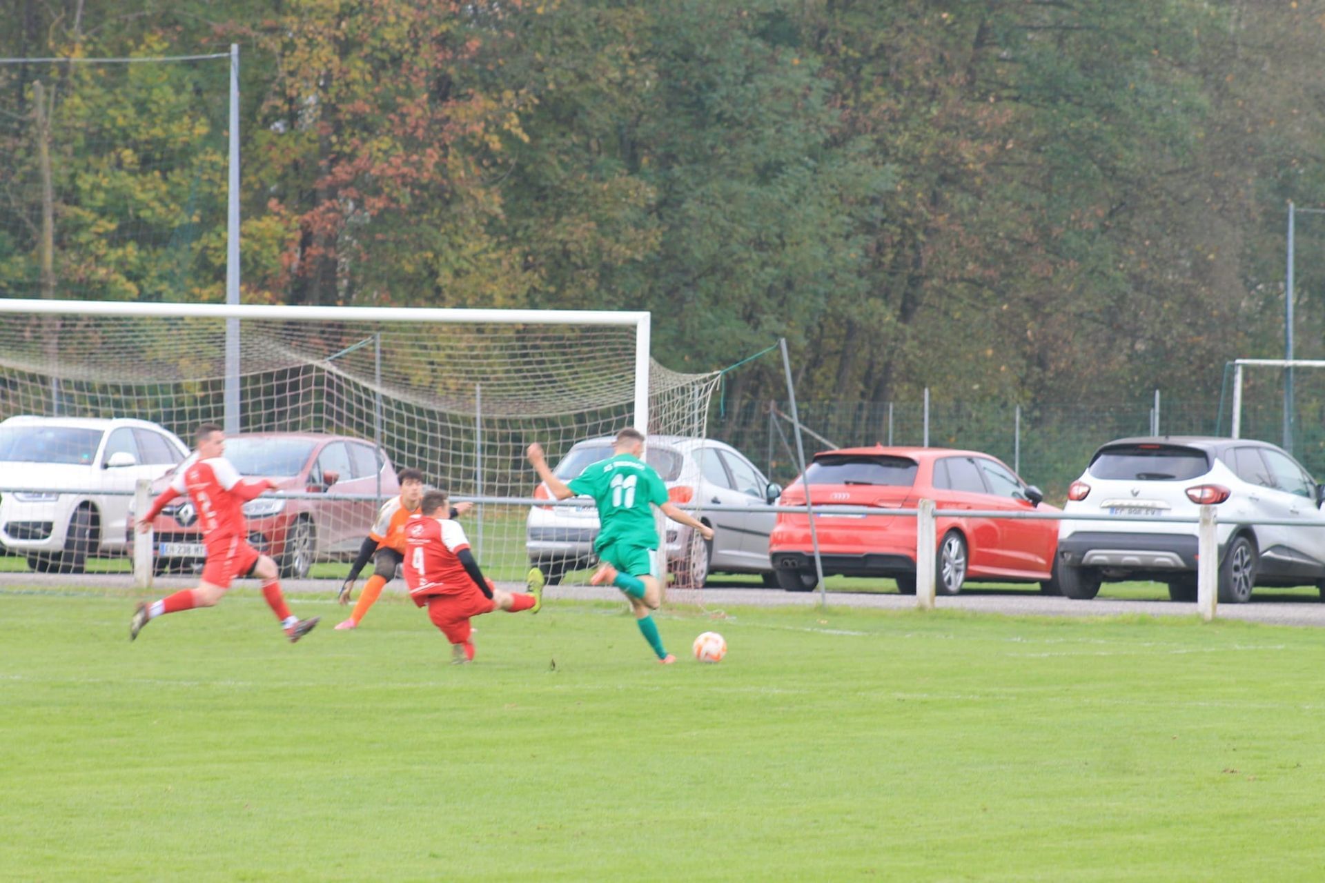 Un groupe de joueurs de football jouent à un jeu sur un terrain.