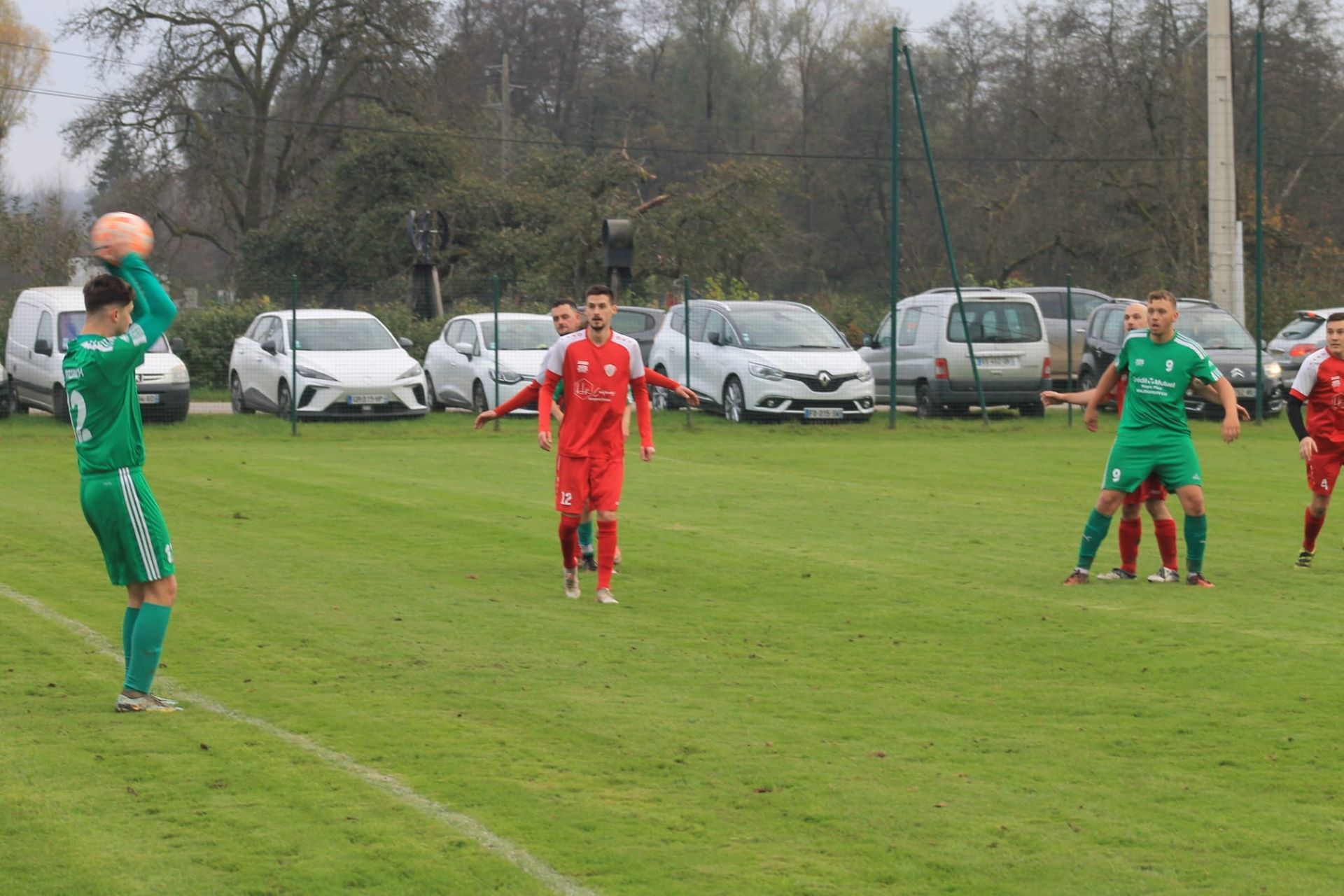 Un groupe de joueurs de football jouent à un jeu sur un terrain.