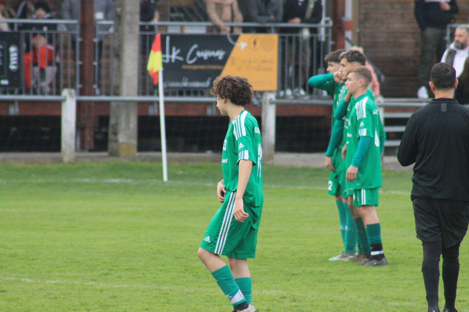Un groupe de jeunes hommes jouent au football sur un terrain.