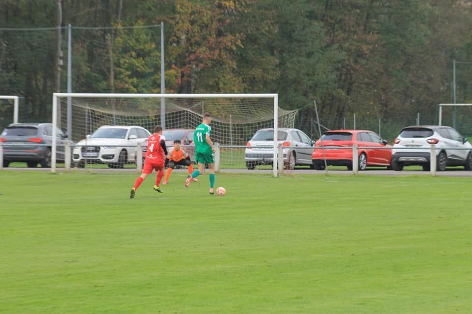 Un groupe de personnes joue au football sur un terrain.