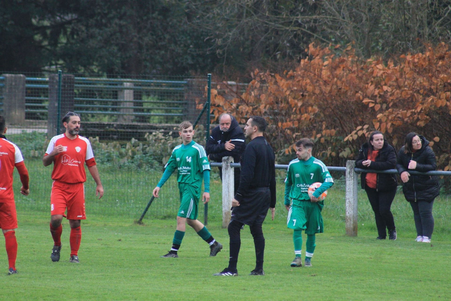 Un groupe de personnes joue au football sur un terrain.