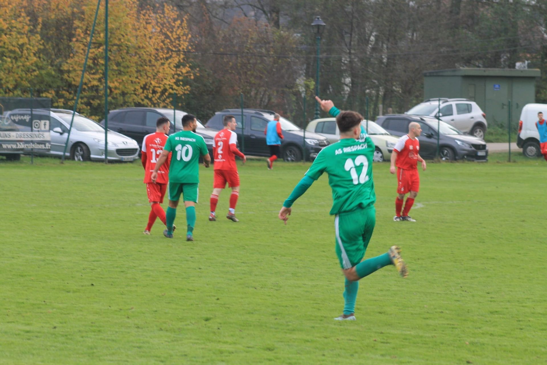 Un groupe de joueurs de football jouent à un jeu sur un terrain.