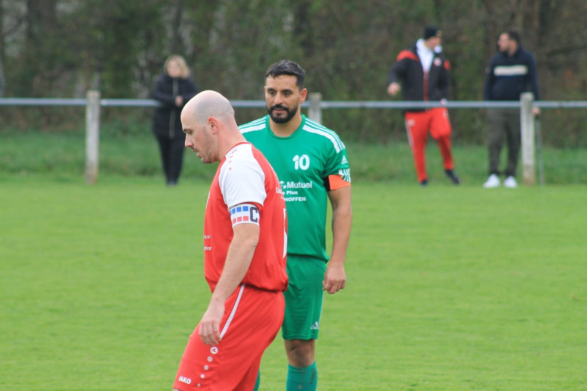 Deux joueurs de football se tiennent côte à côte sur un terrain.