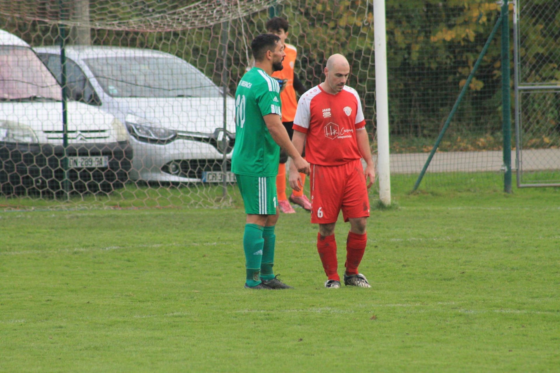 Un groupe de joueurs de football se tiennent sur un terrain et se tiennent la main.