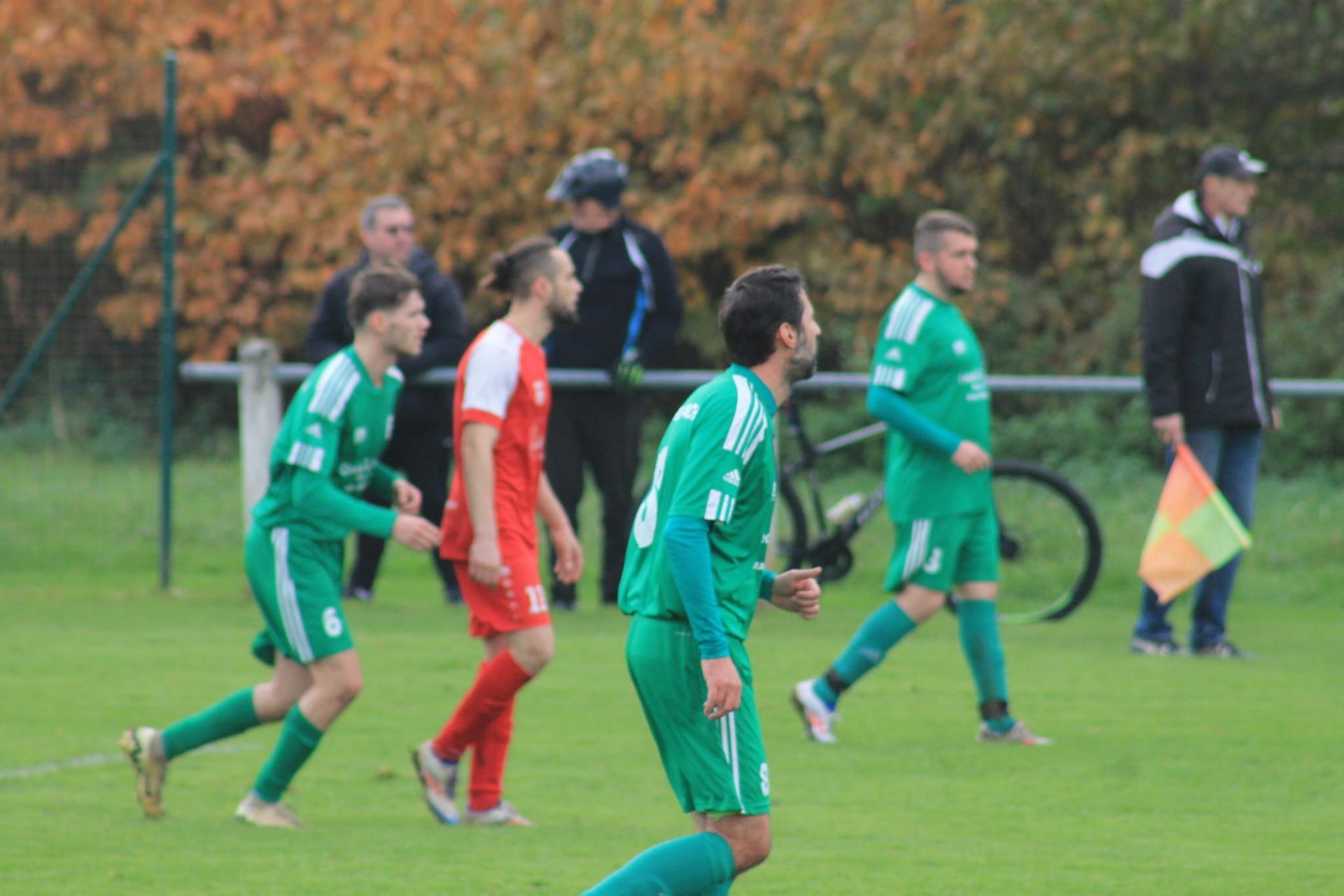 Un groupe d'hommes jouent au football sur un terrain.