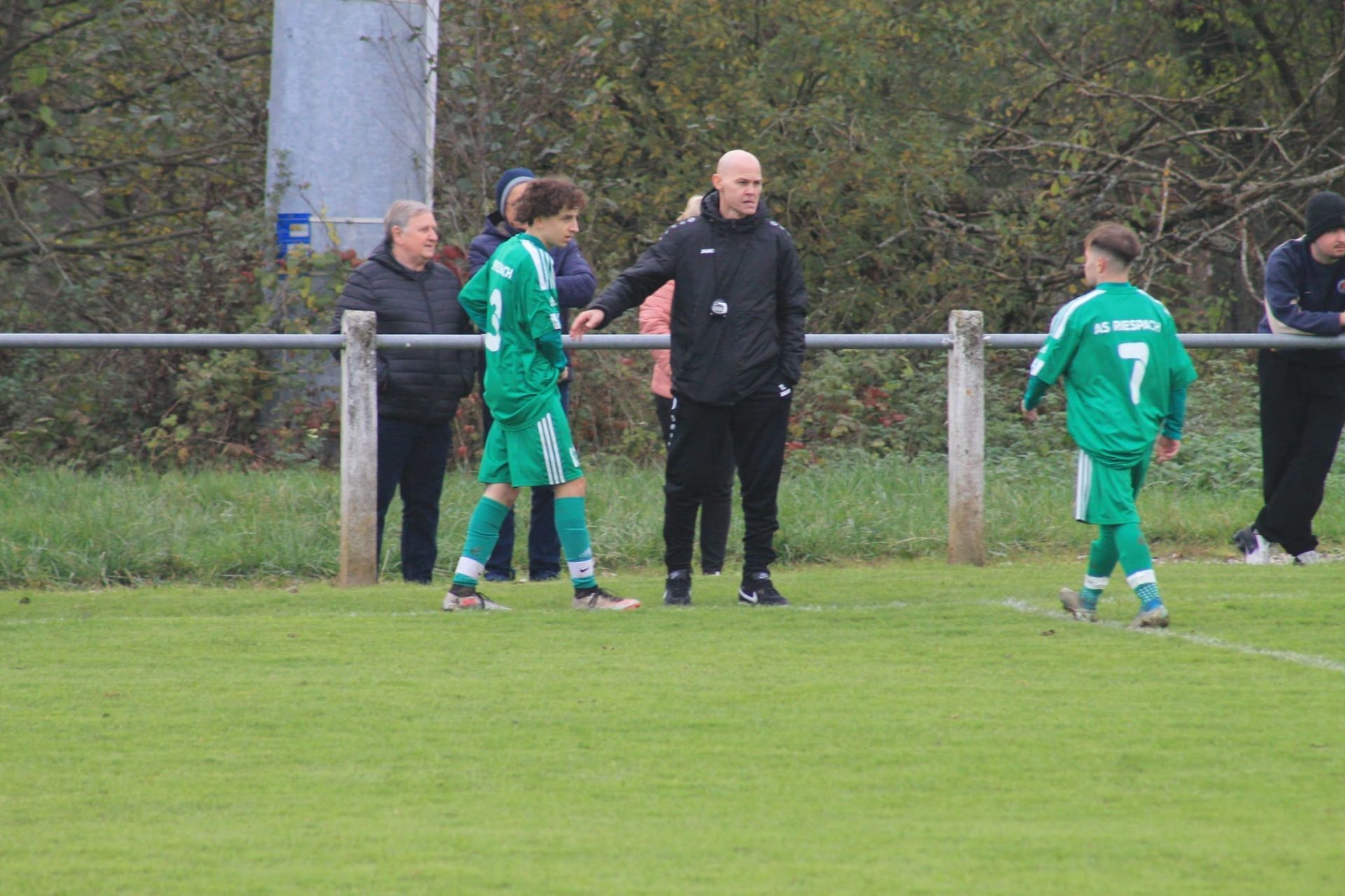 Un groupe de personnes se tient sur un terrain de football.