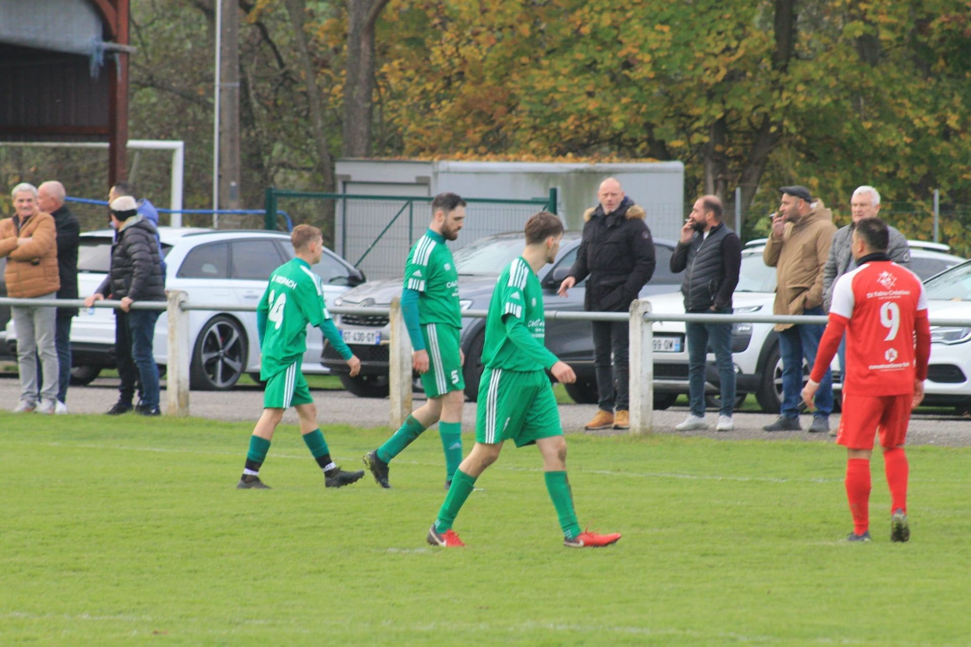 Un groupe de joueurs de football marche sur un terrain.