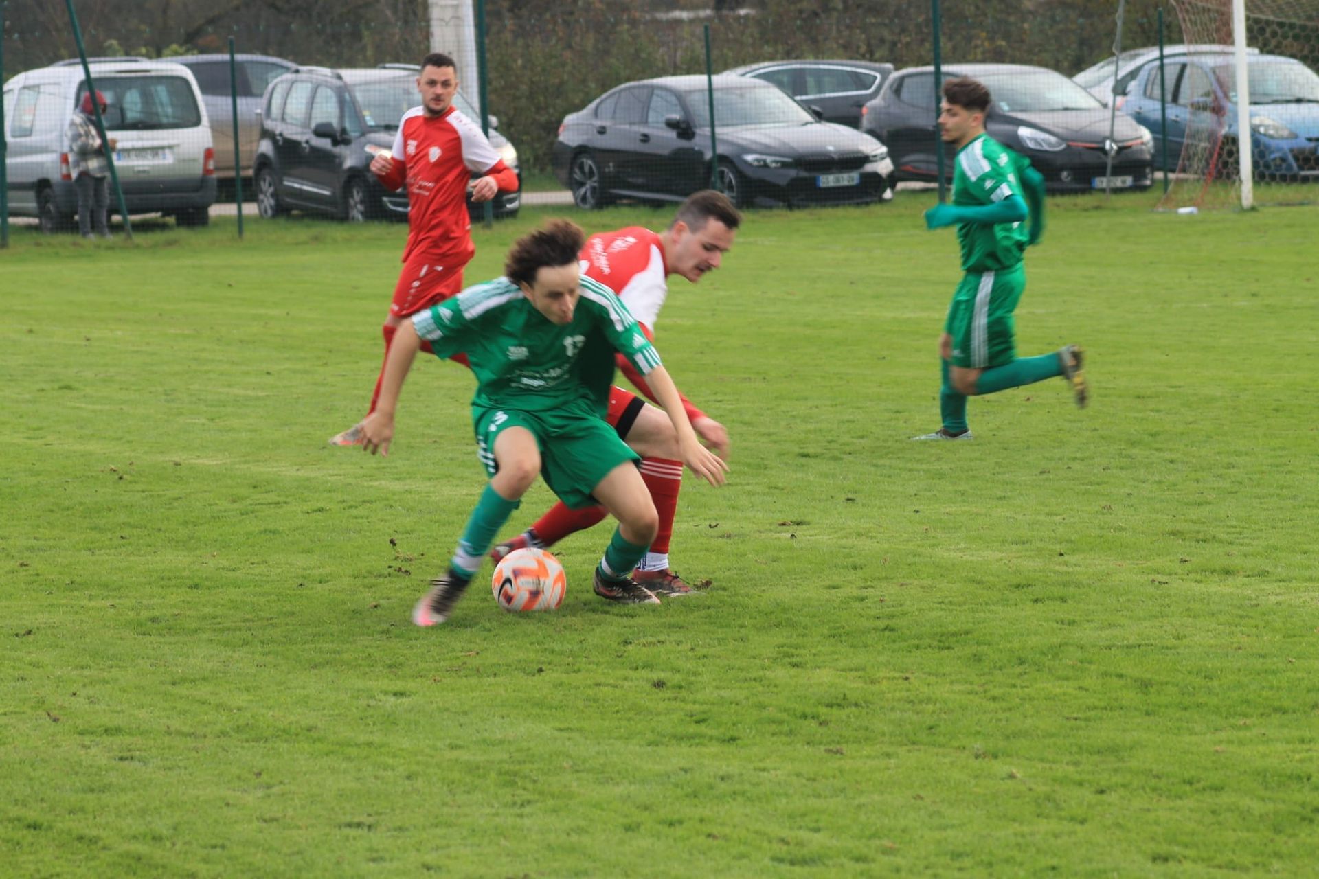Un groupe de jeunes hommes jouent au football sur un terrain.