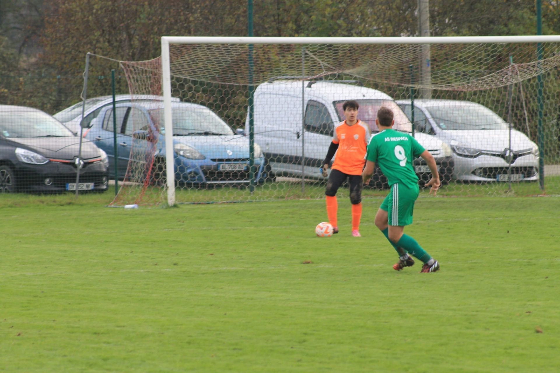 Un groupe de personnes joue au football sur un terrain.