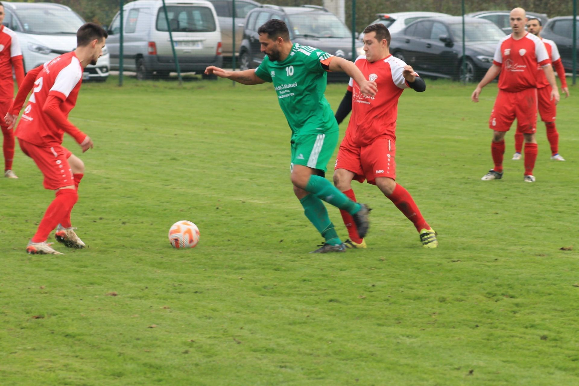 Un groupe d'hommes jouent au football sur un terrain.