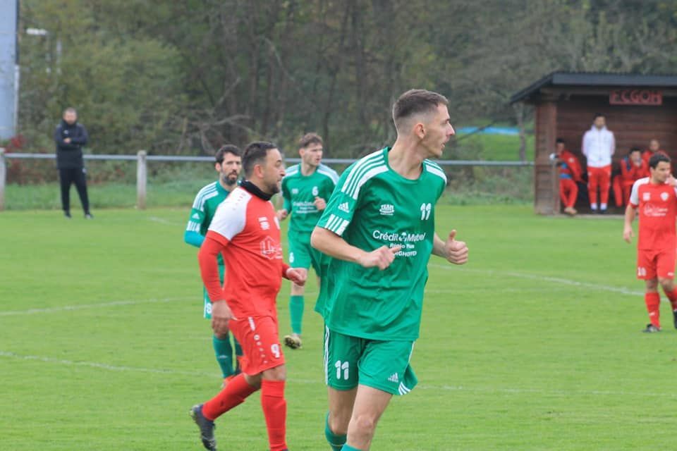 Un groupe de joueurs de football jouent à un jeu sur un terrain.